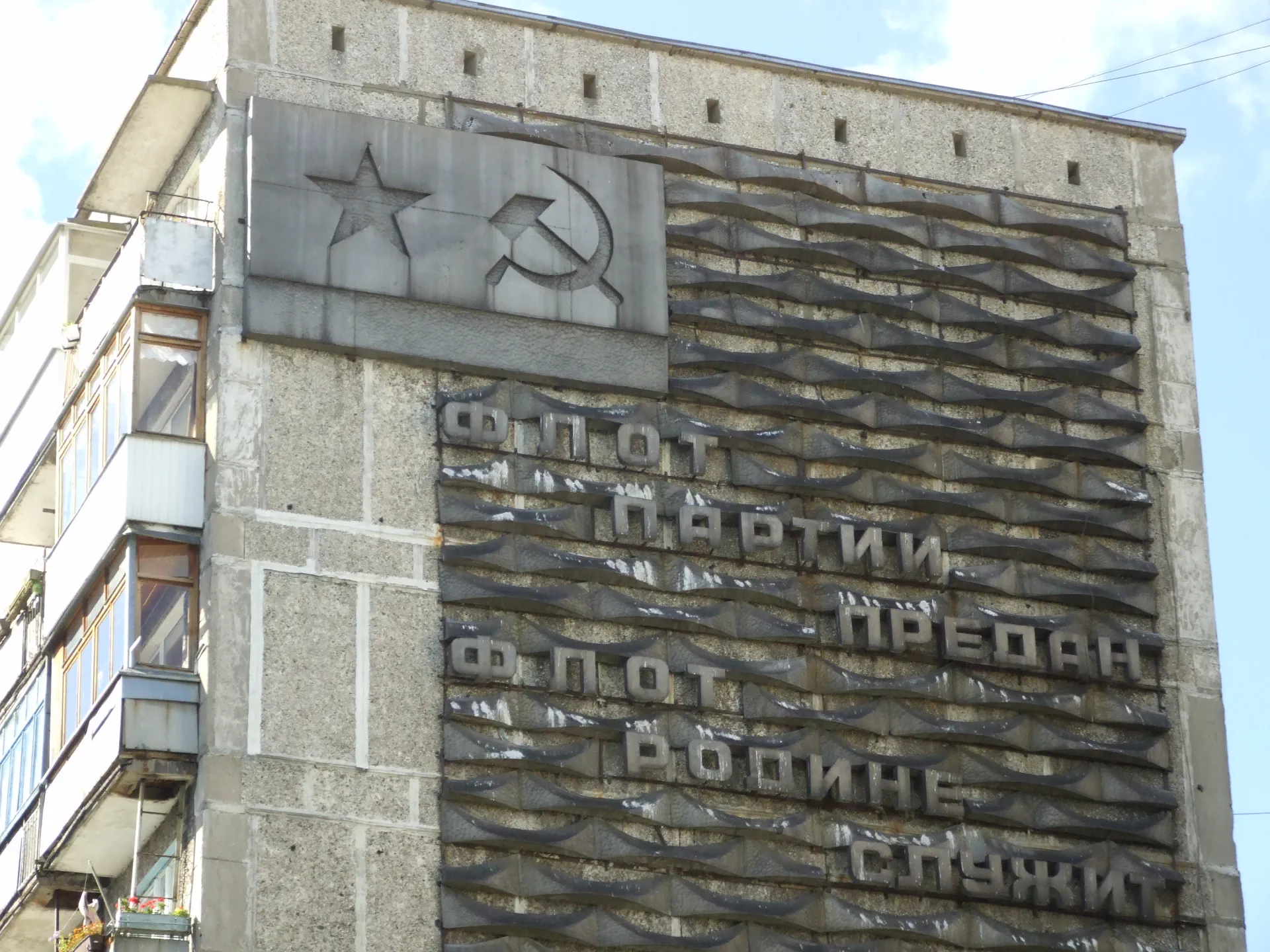 Lozungai ant gyvenamojo namo sovietinėje karinio jūrų laivyno bazėje Baltijske (buv. Piliava): „Laivynas ištikimas partijai, laivynas tarnauja tėvynei“. 2007 m. nuotrauka